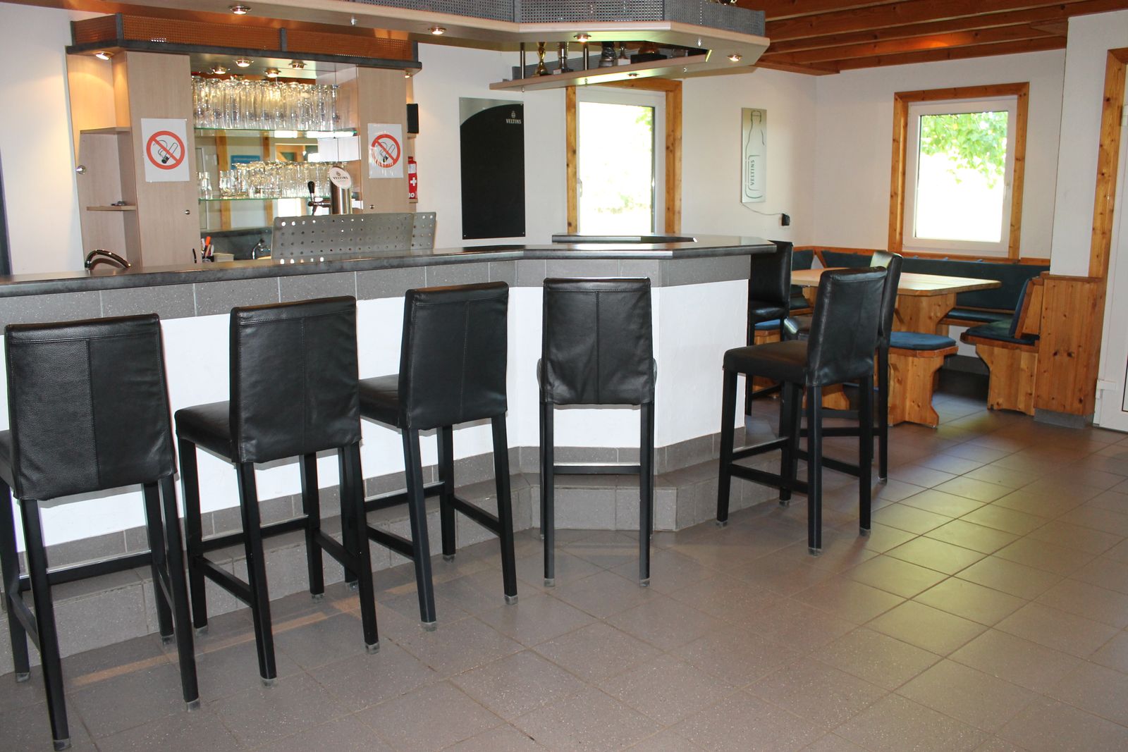 Theke mit Barhockern und Blick durch den Innenraum