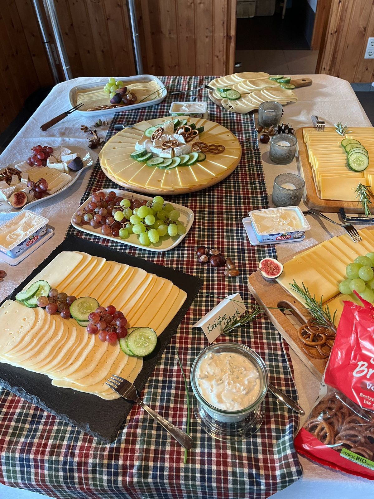 Tisch mit Käseplatten, Trauben und Karotischläufer