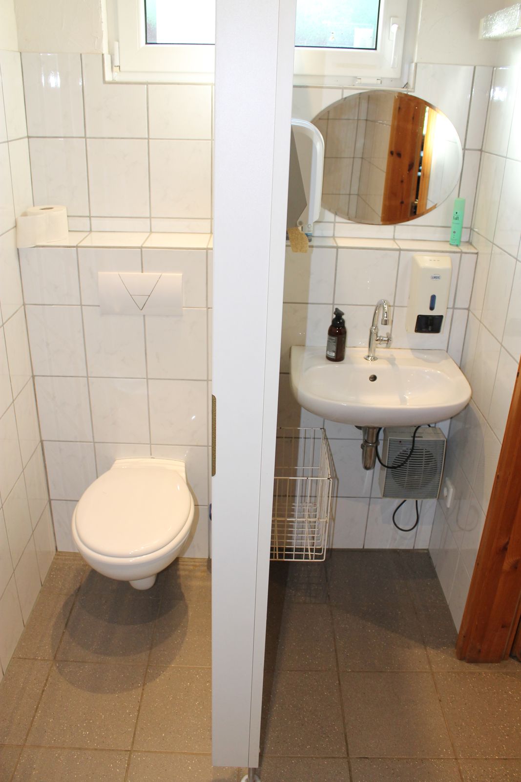 Sauberer WC-Raum mit Waschbecken und Spiegel